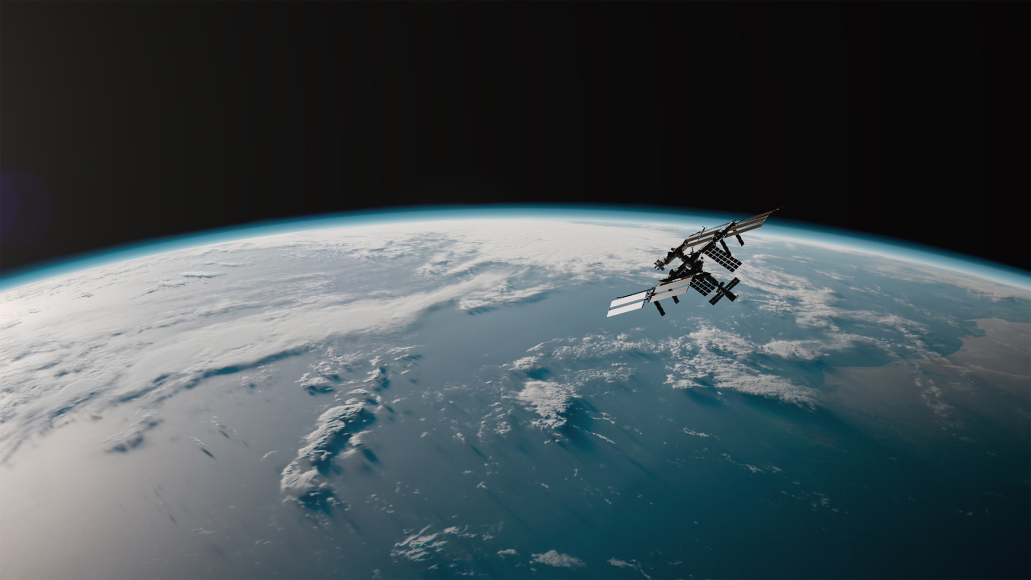 Space station orbiting Earth above cloud-covered ocean and land.