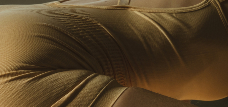 Close-up of a person wearing textured, mustard-colored athletic leggings.