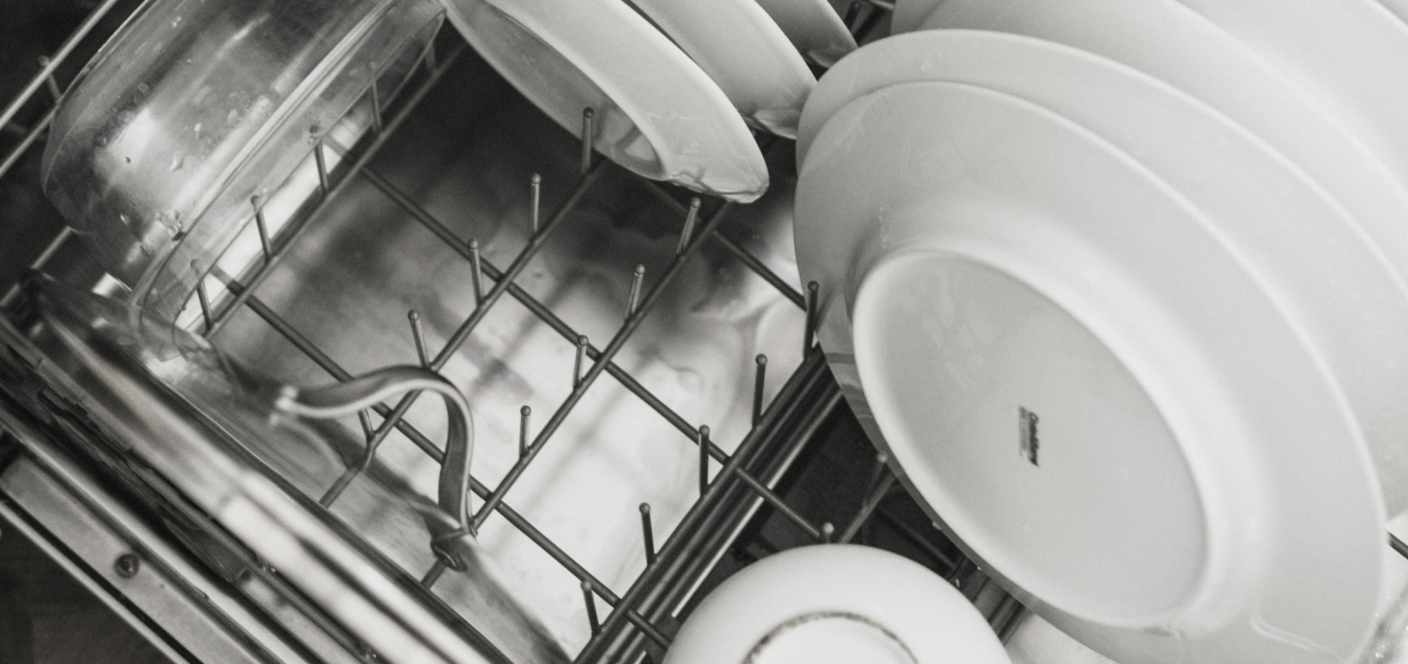 Plates and glassware arranged inside a dishwasher rack.