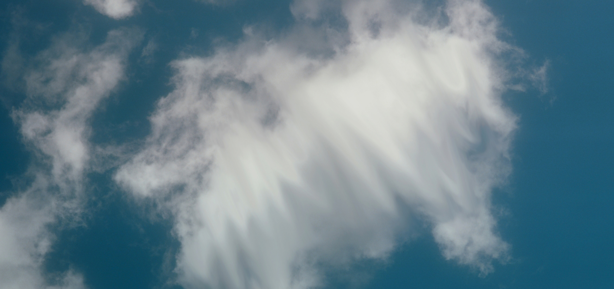 White wispy clouds against a clear blue sky.