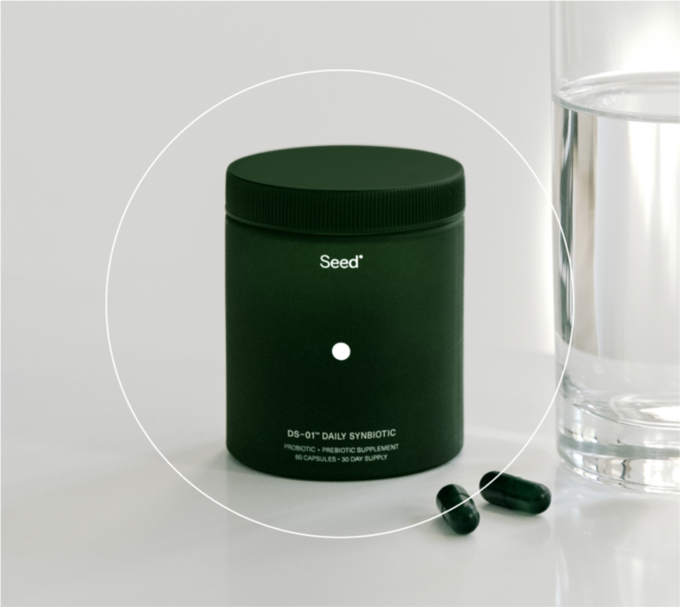 Black container of Med-Lock DS-01 Daily Synbiotic capsules next to a glass of water and two capsules.